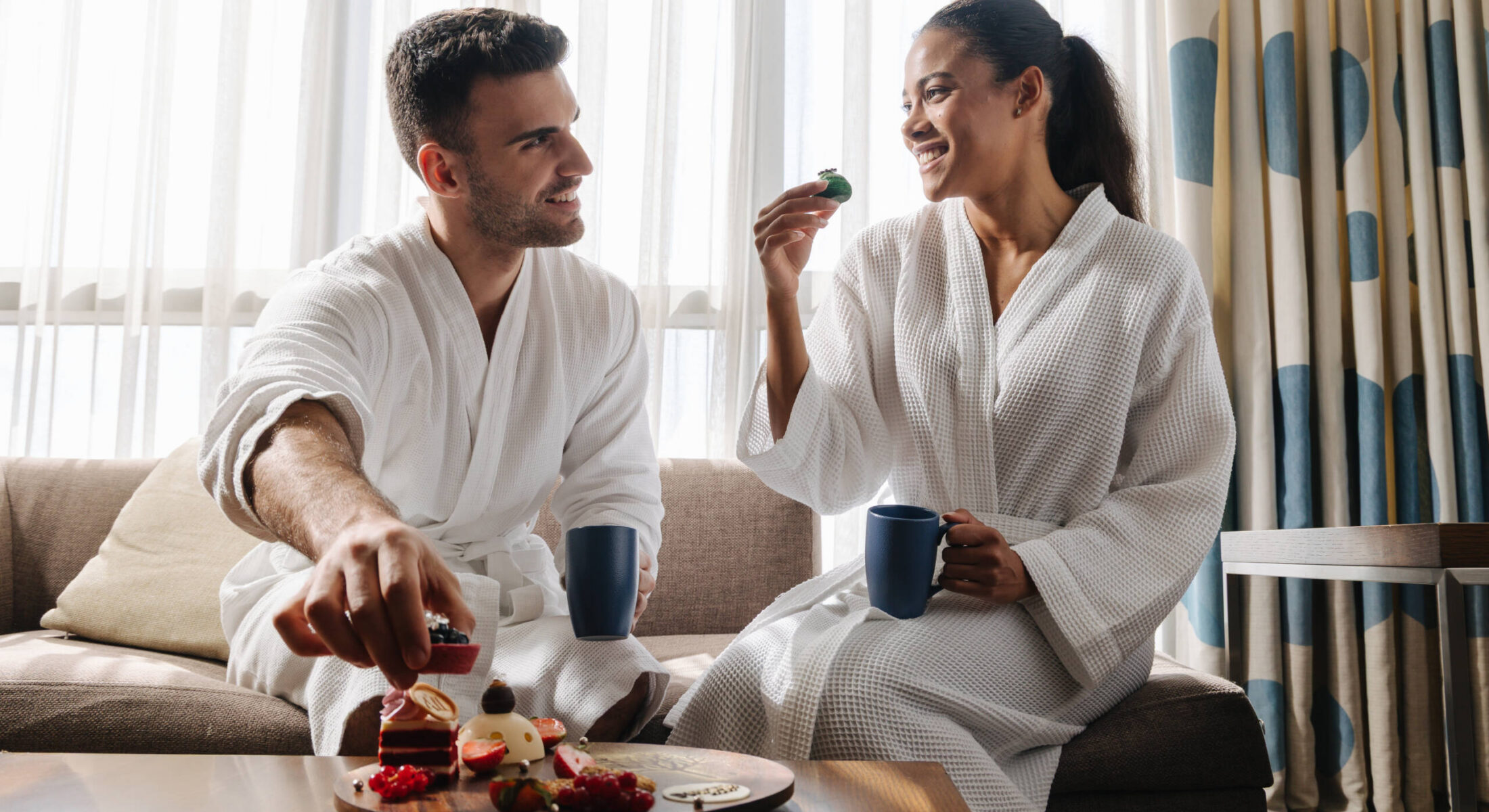 Couple enjoying coffee and desserts in one-bedroom apartment near Grand Mosque Abu Dhabi