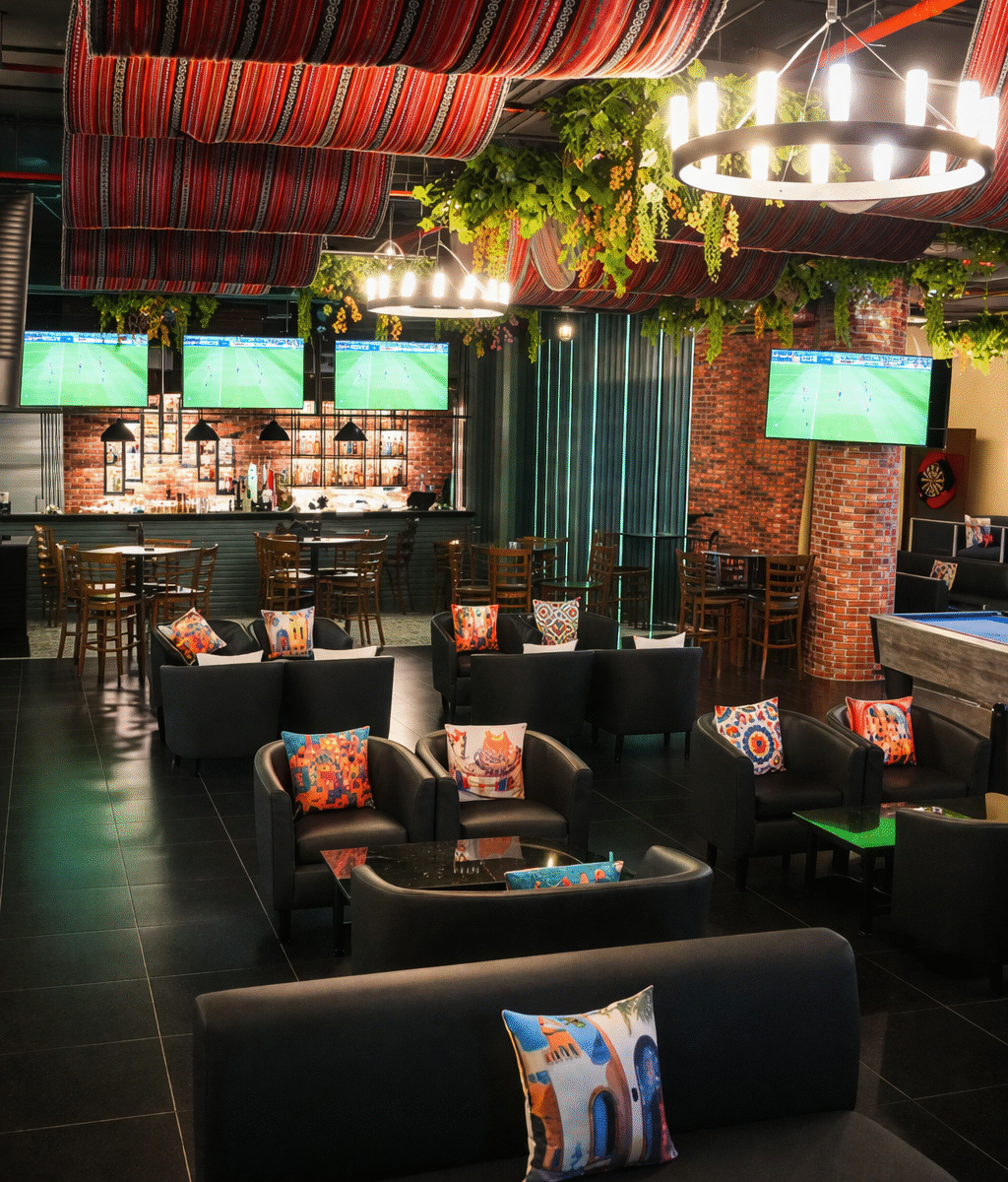 Guests watching live football match at Tiki Taka sports bar in Novotel Gate Abu Dhabi with indoor shisha and burgers